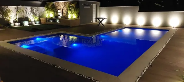 Piscina da residência iluminada à noite