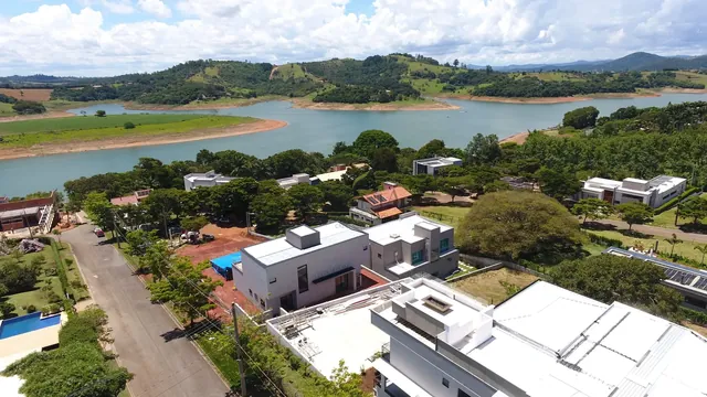 Vista aérea da casa com a represa ao fundo